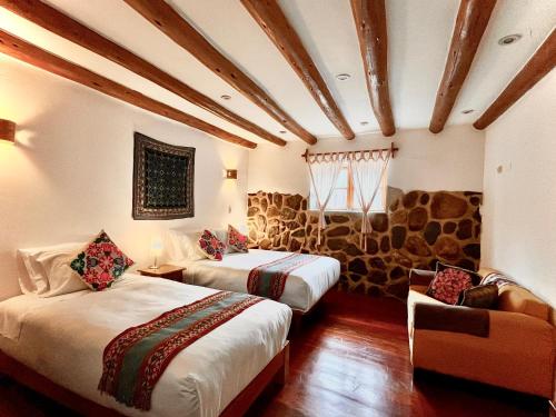 a room with two beds and a couch at Picaflor Tambo Guest House in Ollantaytambo