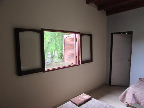a bedroom with two mirrors and a window at Chalet 1 Dormitorio Kallpa in Santiago del Estero