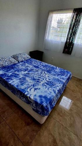 a bed with a blue comforter in a bedroom at MJA's Retreat in Arorangi