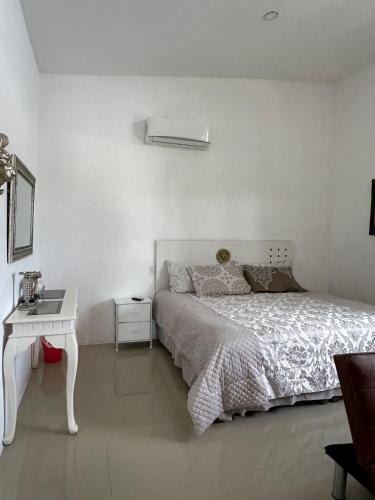a white bedroom with a bed and a white table at Luxury loft with pool and beautiful view in Tampico