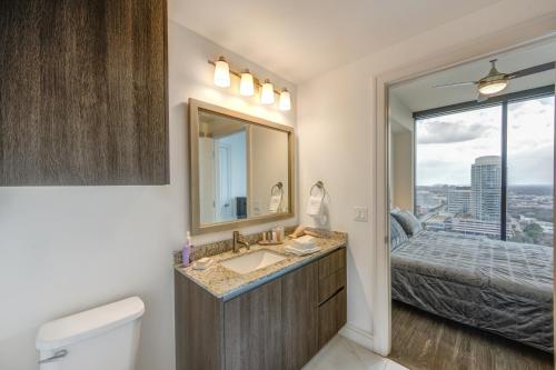 a bathroom with a sink and a bed and a window at Hanover River Oaks in Houston