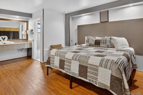 a bedroom with a large bed and a sink at 12 Oaks Hotel in Tyler