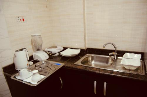a kitchen counter with a sink next to a sink at E-Luxe Suites Hotel in Abuja
