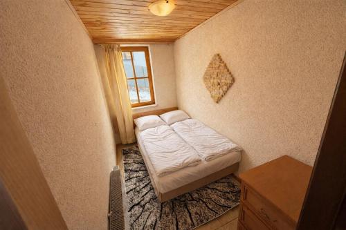 a small bedroom with a bed and a window at Summit View Wisła in Wisła