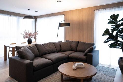 a living room with a brown couch and a table at Luna Ridge - Thoughtfully Designed 3-Bedroom Condo in Revelstoke