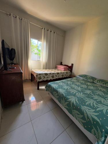 a hotel room with two beds and a window at CasadaKassia in Itapemirim