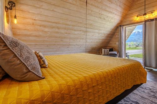 ein Schlafzimmer mit einem gelben Bett in einem Zimmer mit Fenster in der Unterkunft Tiny Town Campground in Emigrant