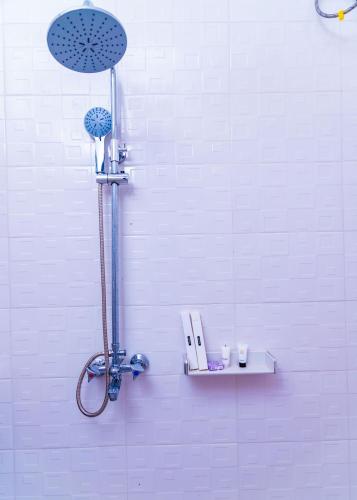 a shower in a white bathroom with a shower head at Grace villa in Zame