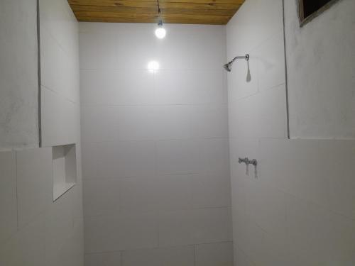 a bathroom with a shower with white walls at Loft 01 encanto dos ipês in Paraty