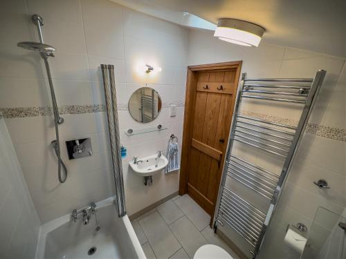 a bathroom with a shower toilet and a sink at All Seasons Cottage Breaks in Saxmundham