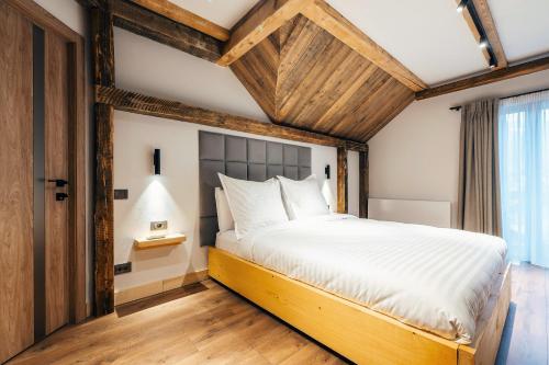 a bedroom with a large bed with a wooden ceiling at Fox Chalet in Molidu