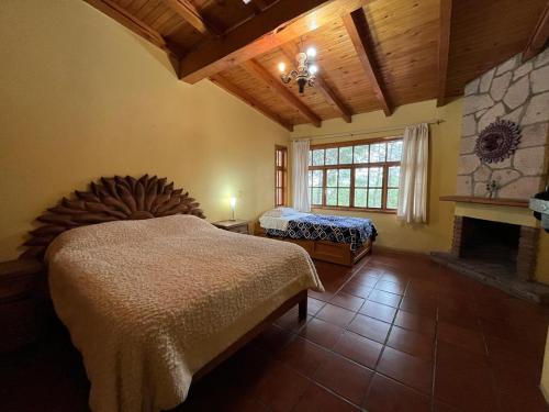 a bedroom with a large bed and a fireplace at Casa del Bosque in Mazamitla