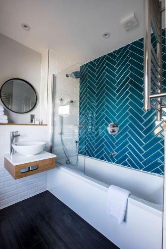 a bathroom with a tub and a sink and a shower at Victoria Inn in London