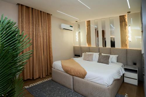 a bedroom with a large bed and a large mirror at Emiez Apartment and Hotel in Benin City