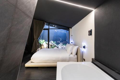 a bedroom with a bed and a large window at Hunter house in Ban Bung Toei