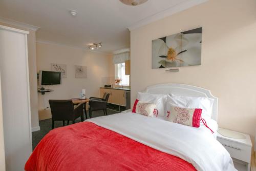 a bedroom with a red and white bed and a desk at Aparthotel Blackpool in Blackpool
