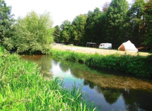 a view of a river with a tent and a field at Farm stay belltent activities in Bramfield