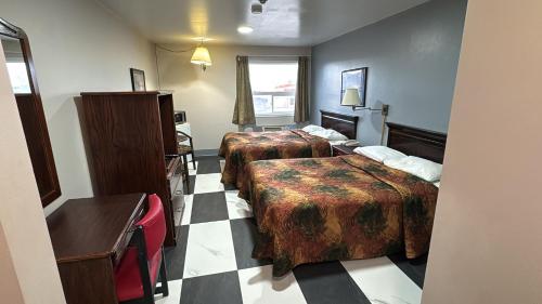 a hotel room with two beds and a window at Burntwood Hotel and Restaurant in Thompson