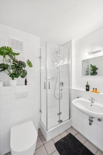 a bathroom with a shower and a toilet and a sink at Go2Cozy - Study & Work Apartments - WIFI - Kitchen in Kaiserslautern