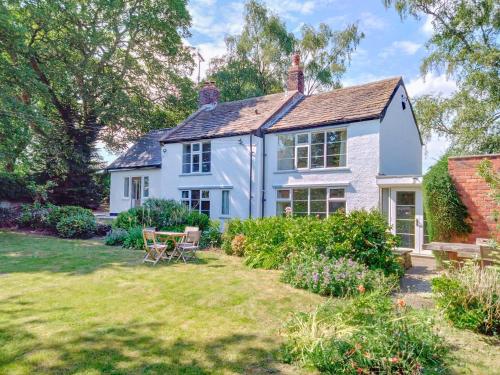 a white house with a garden in front of it at The Mill Cottage in Ault Hucknall