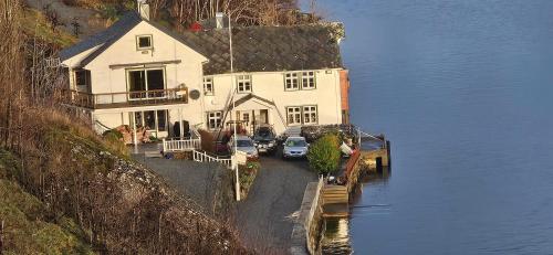 a large house with cars parked next to the water at Hardanger Fjordblikk in Syreflot