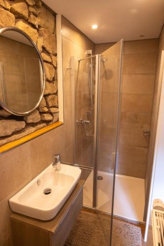 a bathroom with a sink and a shower with a mirror at Haus Eifelglück am Stausee Obermaubach in Kreuzau