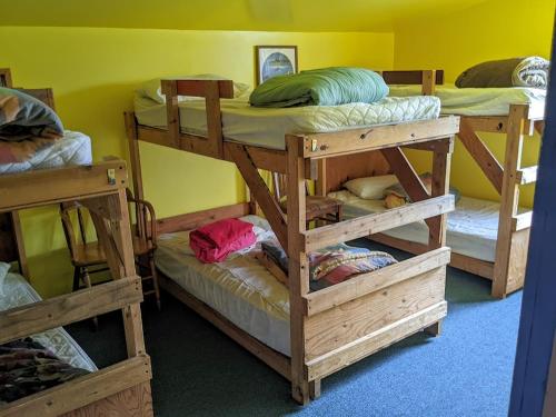 a room with three bunk beds and a yellow wall at MobyDick Hostel in Seward