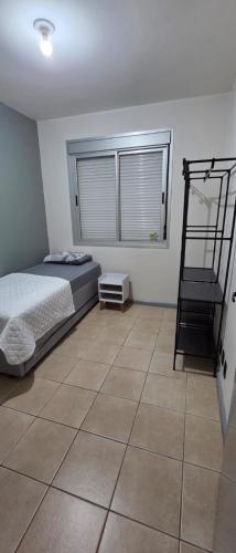 a bedroom with a bed and a staircase in it at Apto térreo aconchego e localização central in Santa Rosa