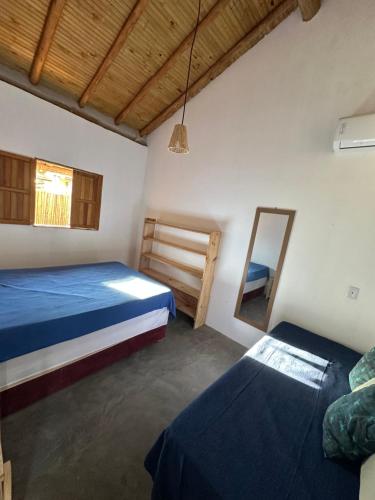 a bedroom with two beds and a mirror at Casa Mojubá in Porto Seguro