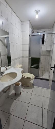 a bathroom with a toilet and a sink and a shower at Apto térreo aconchego e localização central in Santa Rosa