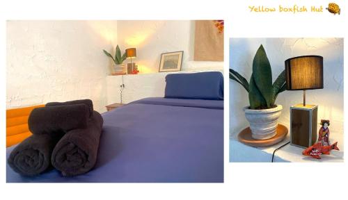 a bedroom with a blue bed and a potted plant at Yellow Boxfish Hut in Ban Thong Phlu