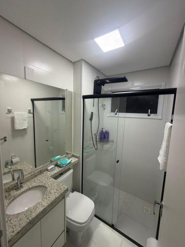 a bathroom with a shower and a toilet and a sink at Apartamento Loretto in Espirito Santo Do Pinhal