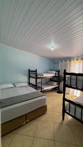 a bedroom with two beds and two trunks at Casa praia e piscina in Bertioga