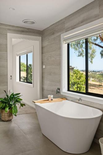 a white tub in a bathroom with a window at An Unforgettable View in Dixons Creek