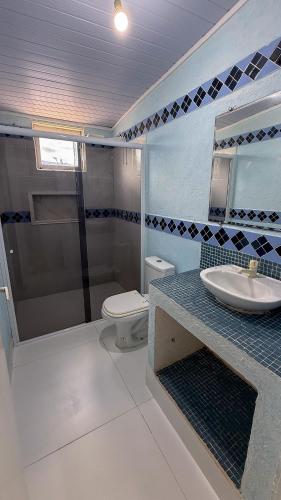 a bathroom with a sink and a shower and a toilet at Casa praia e piscina in Bertioga