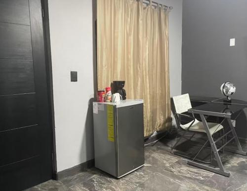 a room with a refrigerator and a table and a chair at Acogedora recámara, con balcón y entrada independiente in Tampico