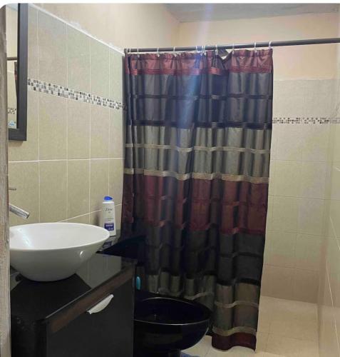 a bathroom with a shower curtain and a sink at Acogedora recámara, con balcón y entrada independiente in Tampico