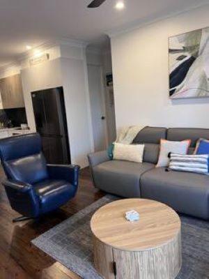 a living room with a couch and a table at Secret at Sussex Inlet Units in Sussex inlet