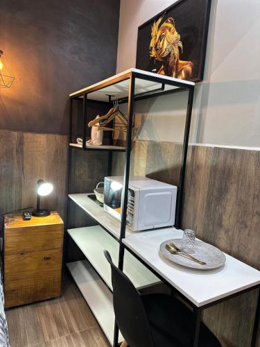 a room with a desk with a microwave at Gold Stay Residence 2 in Belo Horizonte