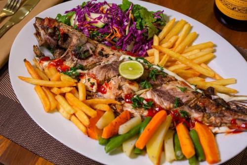 a plate of food with meat and french fries at Harmony Beach Hotel - Tangalle in Tangalle