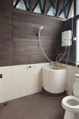 a bathroom with a toilet and a shower at Villa Argapuri Hills in Ciwidey