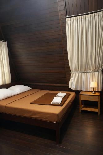 a bedroom with a bed and a window with towels at Villa Argapuri Hills in Ciwidey