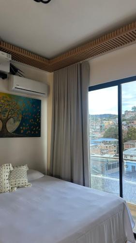 a bedroom with a bed and a large window at Hotel oasis Sevilla Valle in Sevilla
