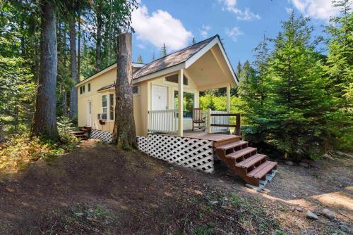 a tiny house in the woods with a porch at New Tiny Home Steps Away From Mt. Rainier in Ashford