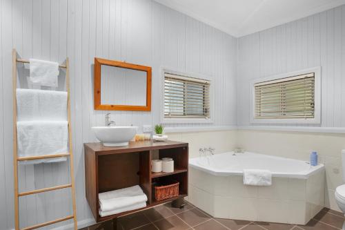 a bathroom with a sink and a tub and a toilet at 27 Rows on Hermitage in Pokolbin