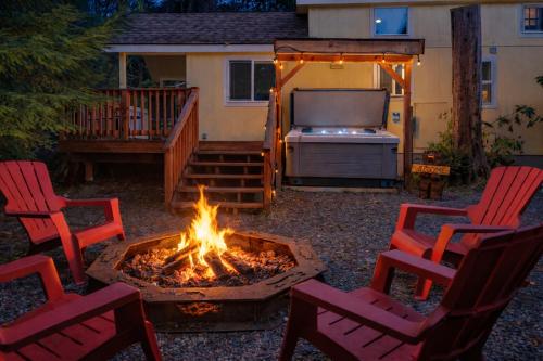 a backyard with a fire pit and chairs and a television at New Tiny Home Steps Away From Mt. Rainier in Ashford