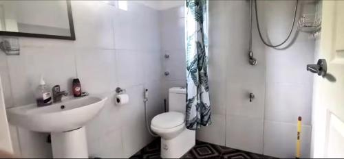 a white bathroom with a toilet and a sink at Designer Villa "Sunset Hills" with Pool in Puerto Princesa City