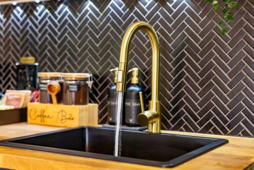 a kitchen sink with a faucet and a sink at Luxury Miami Pool House Private Backyard Oasis Near Wynwood and Miami International Airport in Miami