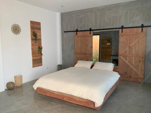 a bedroom with a large bed with a sliding barn door at Studio Thakhek-private loft with terasse in Thakhek