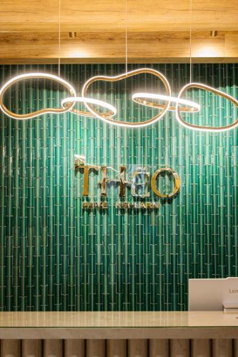 a chandelier hanging from a green tiled wall at Théo Privé Kohlarn in Ko Lan